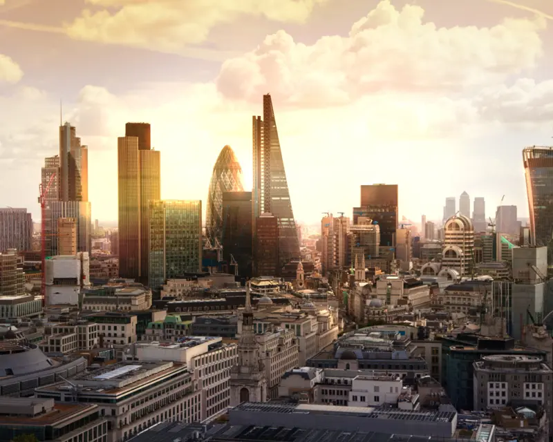 A stunning skyline of modern skyscrapers in London, illuminated by a warm sunset, showcasing the city's vibrant architecture.