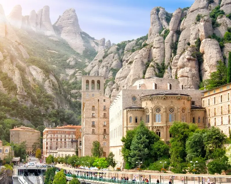 Scenic view of a historic building nestled among towering rocky mountains, showcasing natural beauty and architectural elegance.