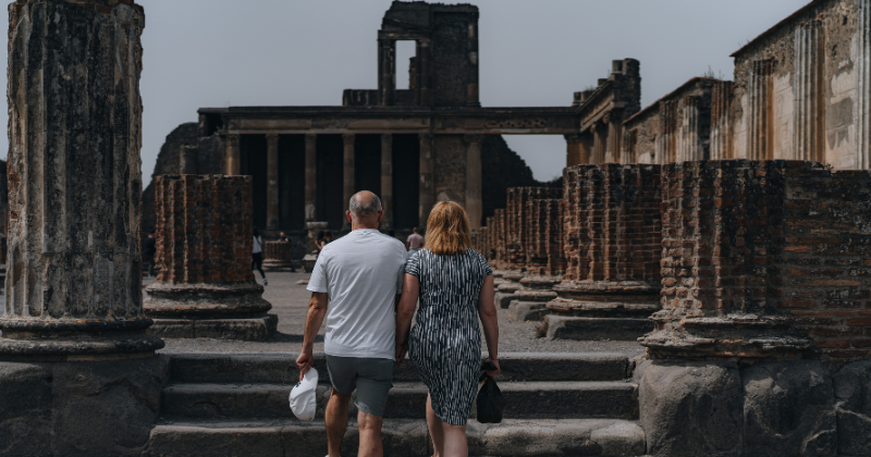 a couple walking hand in hand in ruins