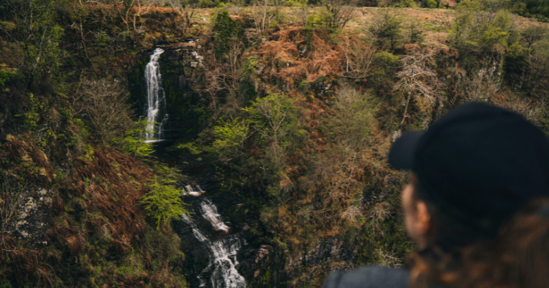 Woman looking out over a waterfall