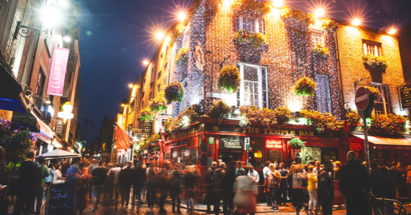 A busy street outside an Irish bar at night