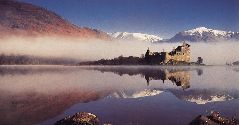 the ruins of Castle Kilchurn reflected in the water of Loch Awe