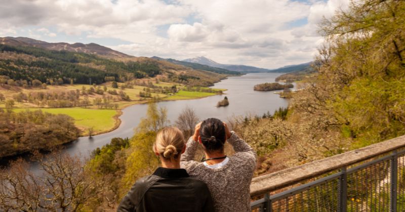 Two people looking out over a lake from a high platform