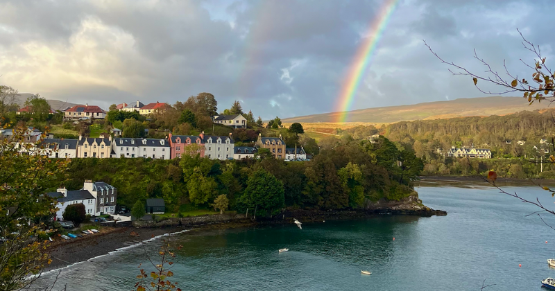 A town by the water with a rainbow