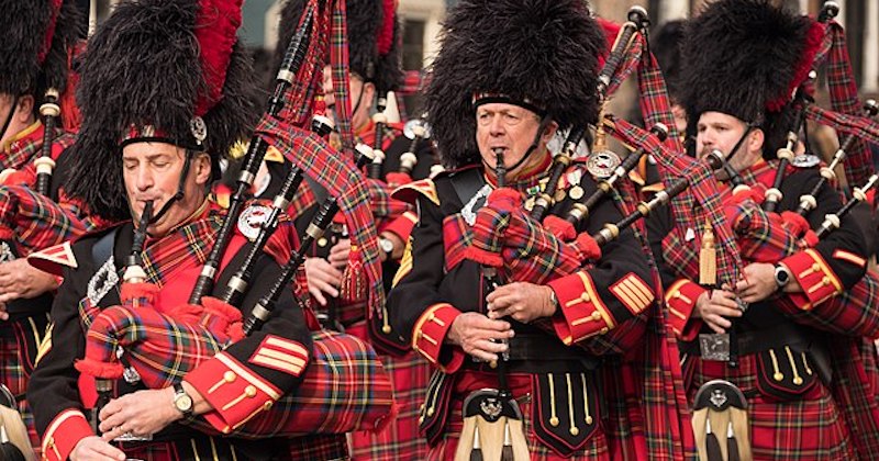 a Scottish Marching band playing bagpipes and dressed in tartans