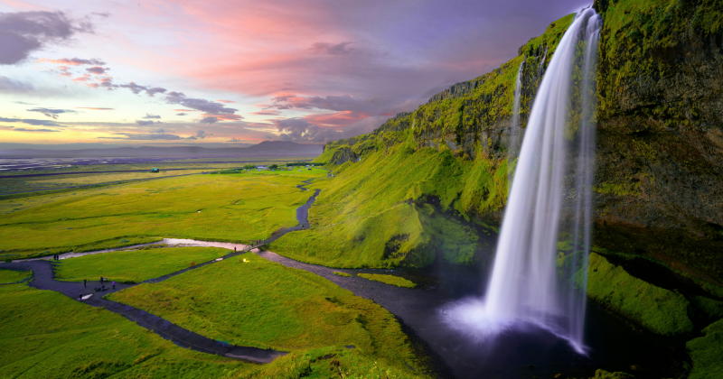 A waterfall surrounded by green landscape