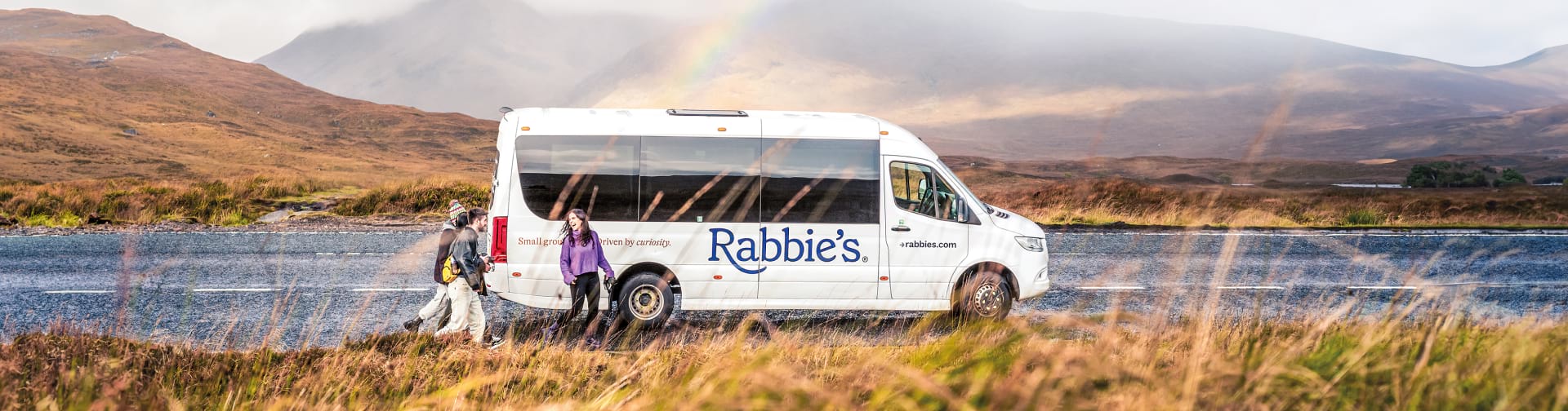 Rabbie's mini coach driving over a bridge in town of Bilbury, the Cotswold's, England.